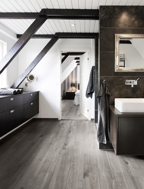 Bathroom in conjunction with bedroom. Structural beams, dark wood and granite tiles.